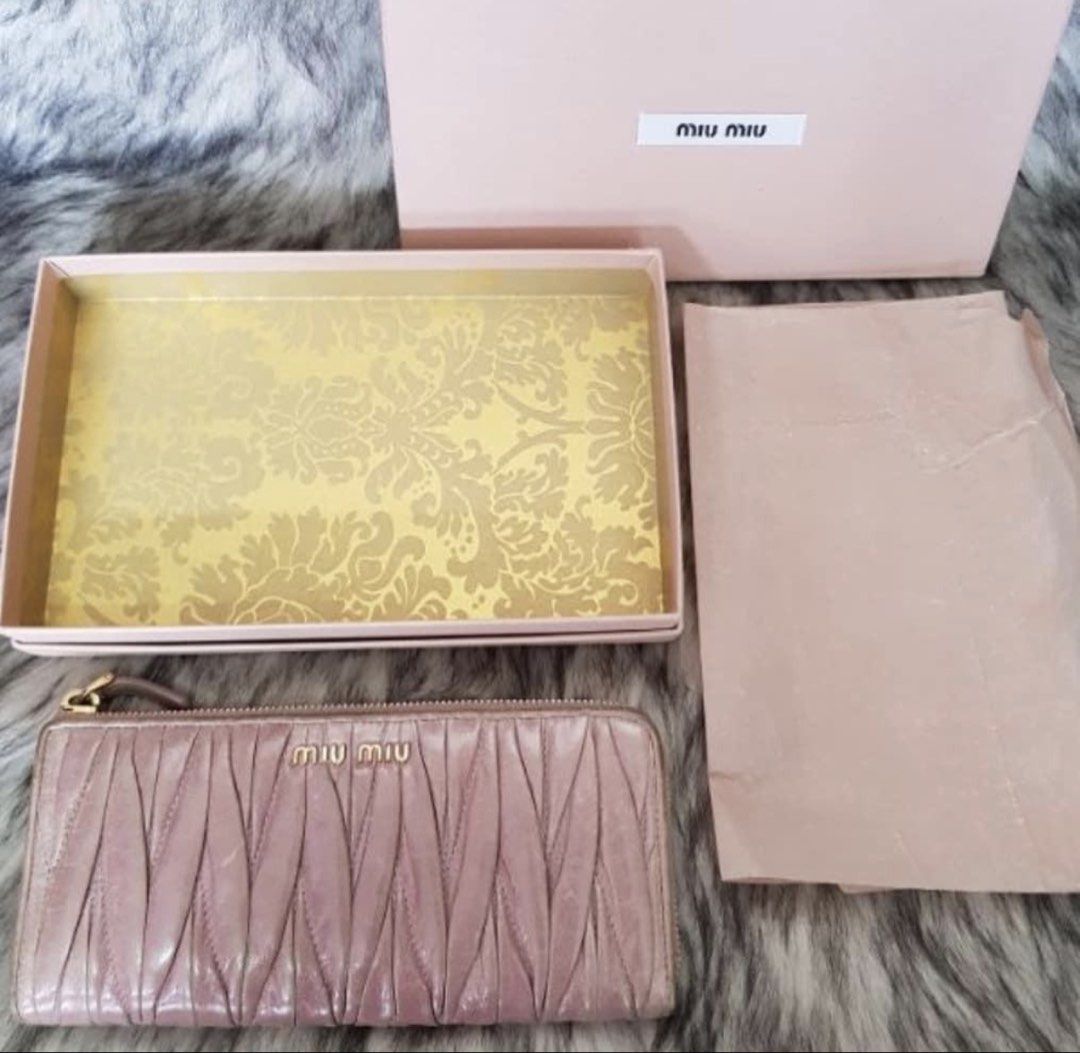 RUSH! Authentic Preloved Miu Miu Long Wallet (Category: Luxury Bags & Wallets) located in Baguio. Submitted by designerbin.ph (Listing ID 1451265138, Image 1). Description: Authentic Preloved Miu Miu Long Wallet Condition: Signs of normal use. Dirt on leather. Wear on edges. No major flaw. Measurement: Credit Card Slots - 8 Bill Compartment - 2 Zippered Pocket - 1 Slip Pocket - 2 ID Window - None H - 8.5 cm W -19 cm D - 2 cm Inclusion/s: Box Auth