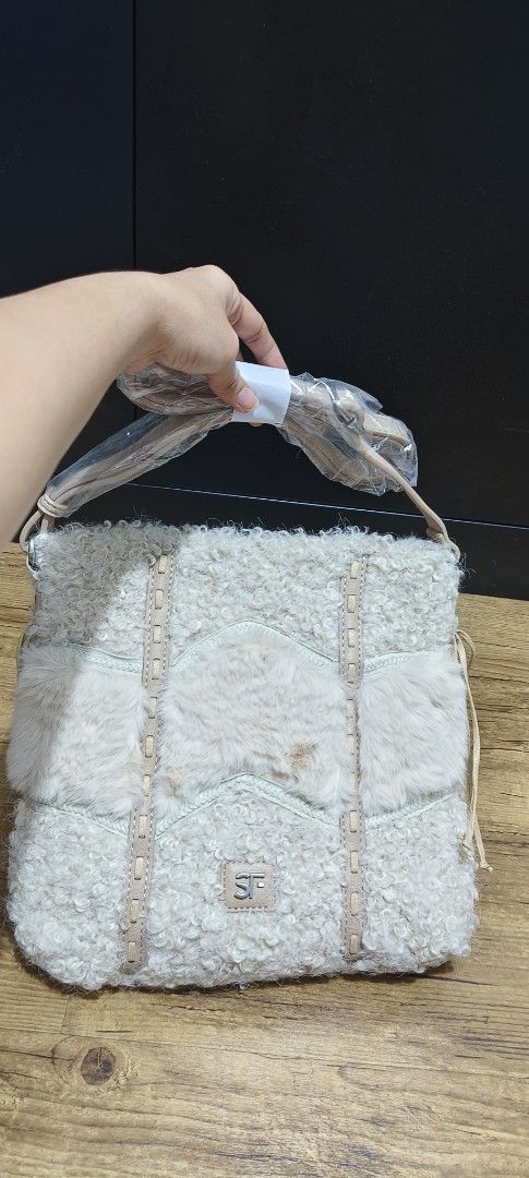 Brand new Fur Bag Cream (Category: Cross-body Bags) located in Cavite. Submitted by house_of_tabitha (Listing ID 1451155858, Image 2). Description: - Brand new cream shearling bag - Fluffy texture - Detachable strap included - Light tan leather accents - Features the SF logo in the center - Tags are still attached - super nice in actual.