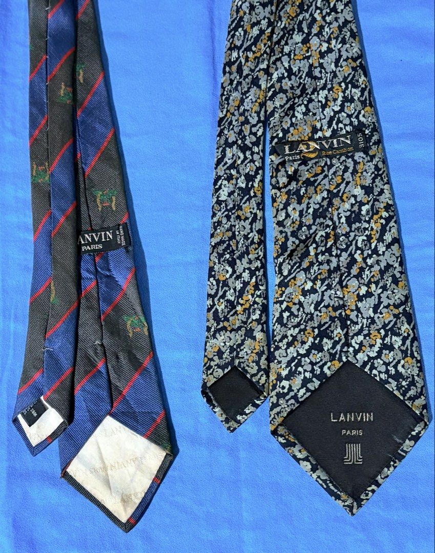 BUNDLE Lanvin Paris Silk Ties (2 pcs) (Category: Ties) located in Manila. Submitted by truedeclutter (Listing ID 1451193758, Image 2). Description: - Two authentic Lanvin Paris silk ties - One features blue and grey stripes with a green emblem - The other is dark blue with a floral pattern - Both ties are 100% silk - Versatile for formal or casual wear - Please check photos for detailed condition.