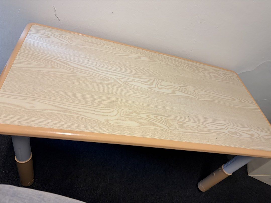 Children’s table (Category: Tables & Sets) located in Singapore. Submitted by ppingqii (Listing ID 1451136855, Image 2). Description: - Lightweight and portable - Adjustable leg height for versatility - Wood grain finish tabletop - Some pencil and glue markings (can be wiped/scrubbed off) - Small crack on one leg casing (from when we moved it previously) - Ideal for casual use.