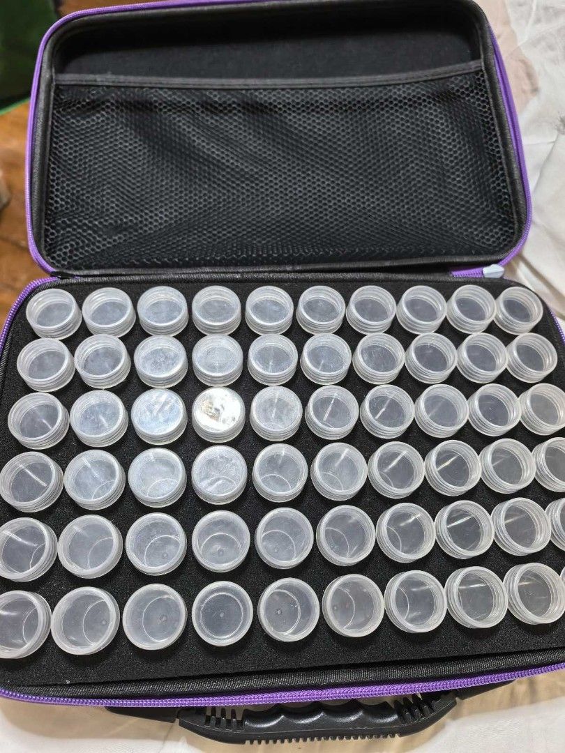 Diamond Painting Storage Case with Accessories (Category: Craft Supplies & Tools) located in Quezon City. Submitted by purple_chick (Listing ID 1451180217, Image 1). Description: - Black organizer case with purple trim and handle - Features many small clear containers for beads or gems - Comes with various tools like pens, a small blue eraser, and other accessories in sealed bags - Ideal for organizing diamond painting supplies.