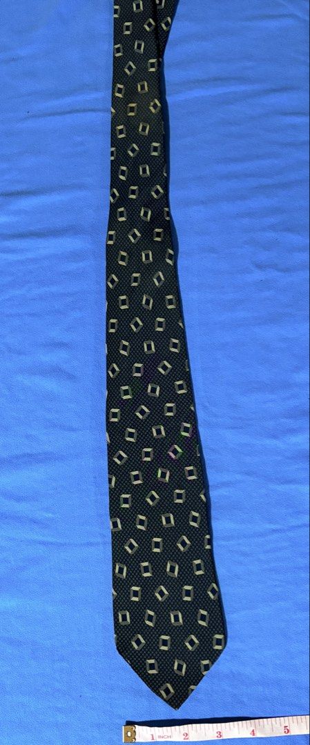 Fendi Roma Silk Tie (Category: Ties) located in Manila. Submitted by truedeclutter (Listing ID 1451202710, Image 1). Description: - Classic Fendi tie - Geometric pattern: Dark navy base with beige and green diamond shapes - Material: 100% Silk - Perfect for formal occasions or adding luxury to any outfit - Length: Approximately 57 inches - Widest part of blade: Approximately 3.5 inches.