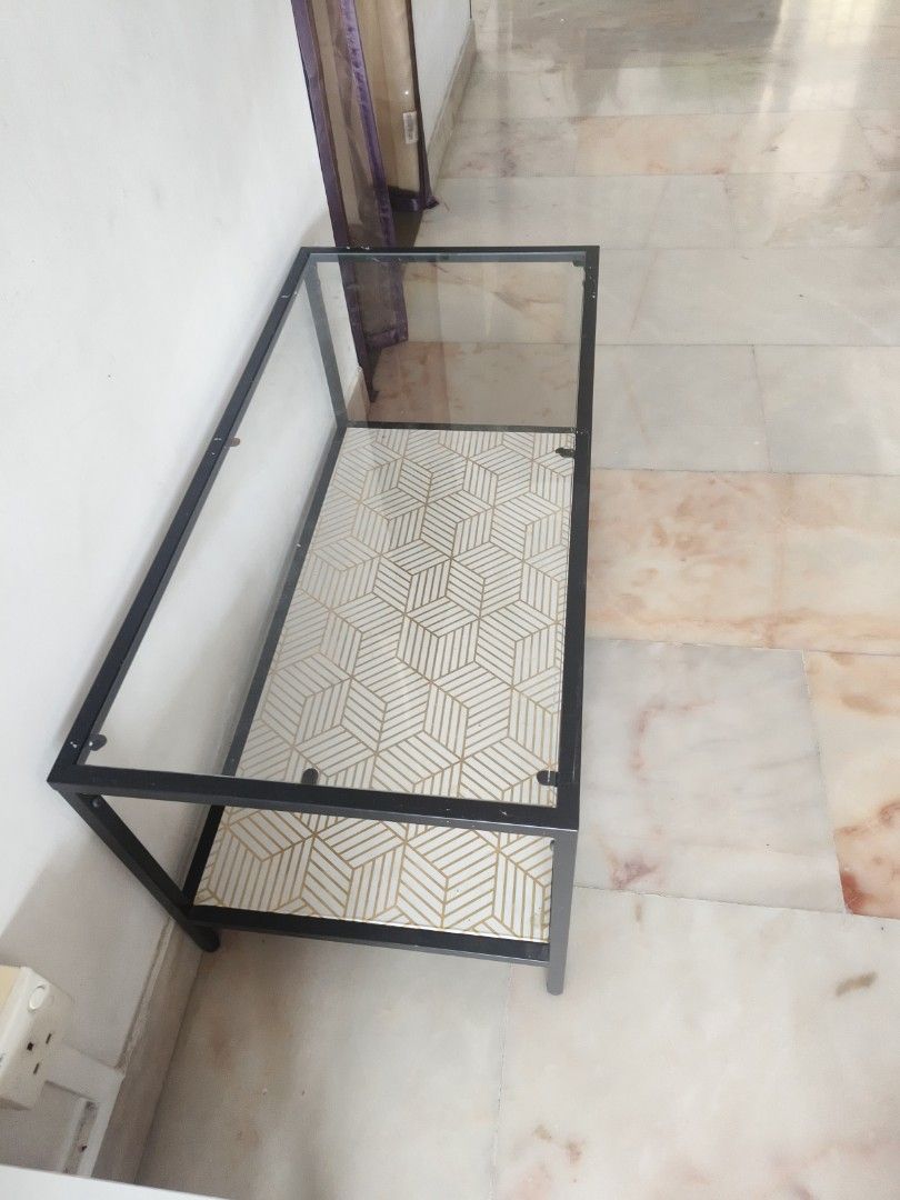 Geometric Pattern Coffee Table (Category: Tables & Sets) located in Singapore. Submitted by yapbibi8351536 (Listing ID 1447831682, Image 3). Description: - Two-tier coffee table - Black metal frame - White mesh top shelf - Geometric patterned bottom shelf (white & gold) - Ideal for living room or study - Easy to assemble.