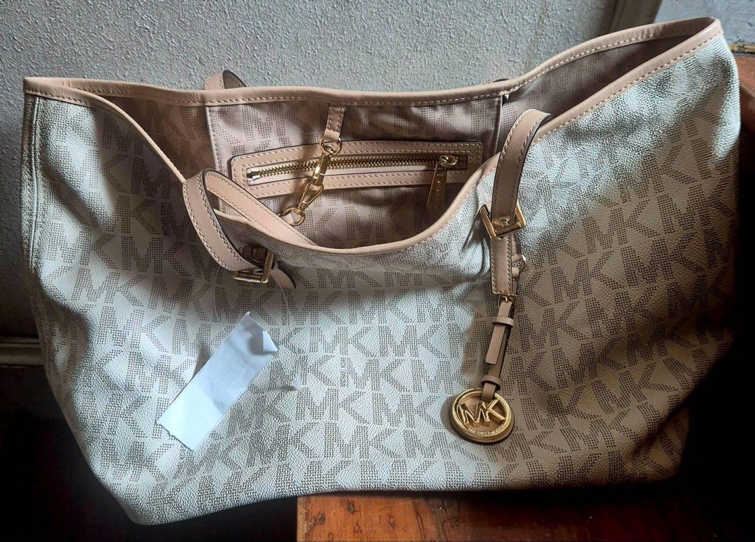 Michael Kors White Monogram Tote Bag (Category: Luxury Bags & Wallets) located in Makati City. Submitted by qchezka (Listing ID 1451198077, Image 2). Description: - White Michael Kors tote bag - Signature MK monogram print - Beige leather trim and handles - Gold tone hardware - Interior zip pocket and slip pockets - Spacious for everyday use.