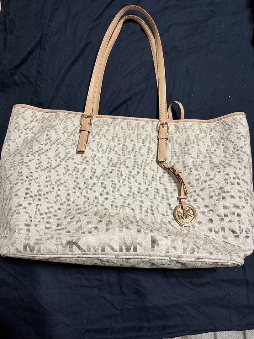 Michael Kors White Monogram Tote Bag (Category: Luxury Bags & Wallets) located in Makati City. Submitted by qchezka (Listing ID 1451198077, Image 1). Description: - White Michael Kors tote bag - Signature MK monogram print - Beige leather trim and handles - Gold tone hardware - Interior zip pocket and slip pockets - Spacious for everyday use.