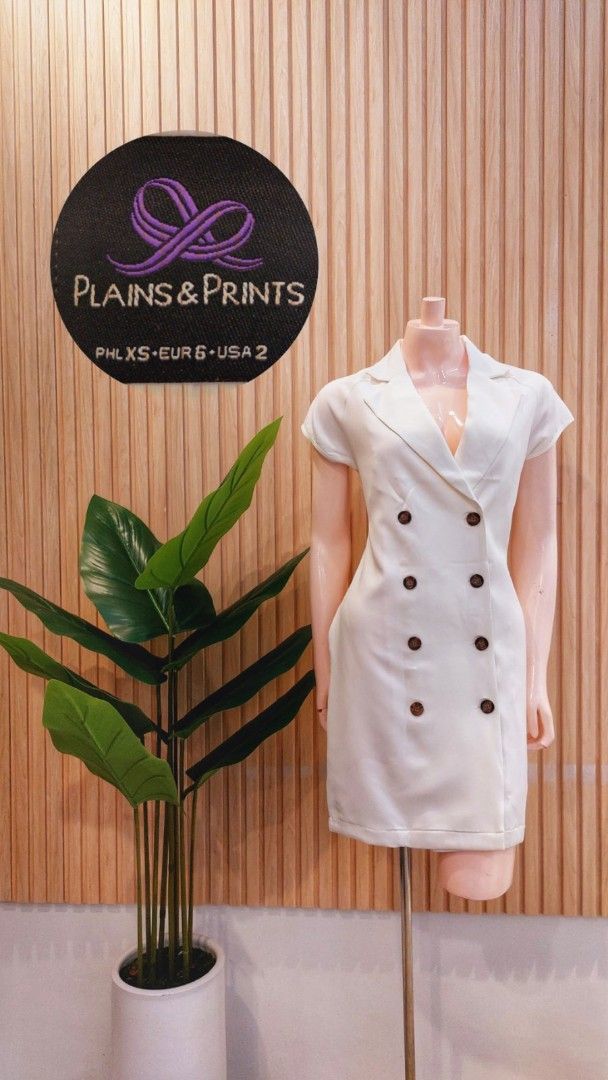 Plains & Prints White Double-Breasted Blazer Dress (Category: Dresses) located in Angeles City. Submitted by leichen57360 (Listing ID 1451173030, Image 1). Description: - White Plains & Prints blazer dress - Double-breasted style with brown buttons - Short sleeves - Estimated size XS - Versatile for work or a night out.