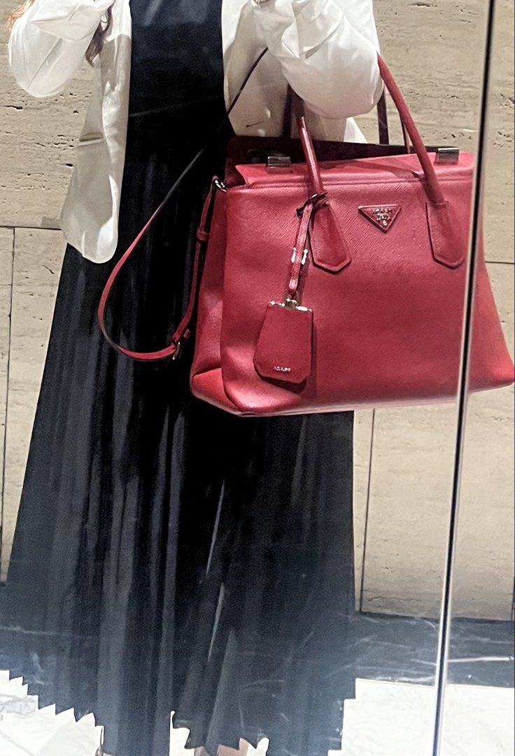 Prada Saffiano Leather Top Handle Bag (Category: Luxury Bags & Wallets) located in Makati City. Submitted by classyandchic (Listing ID 1451293617, Image 3). Description: - Authentic Red Prada Saffiano Leather Bag - Features top handles and a detachable shoulder strap - silver hardware - Comes with entrupy authentication - with stain (can be removed) .