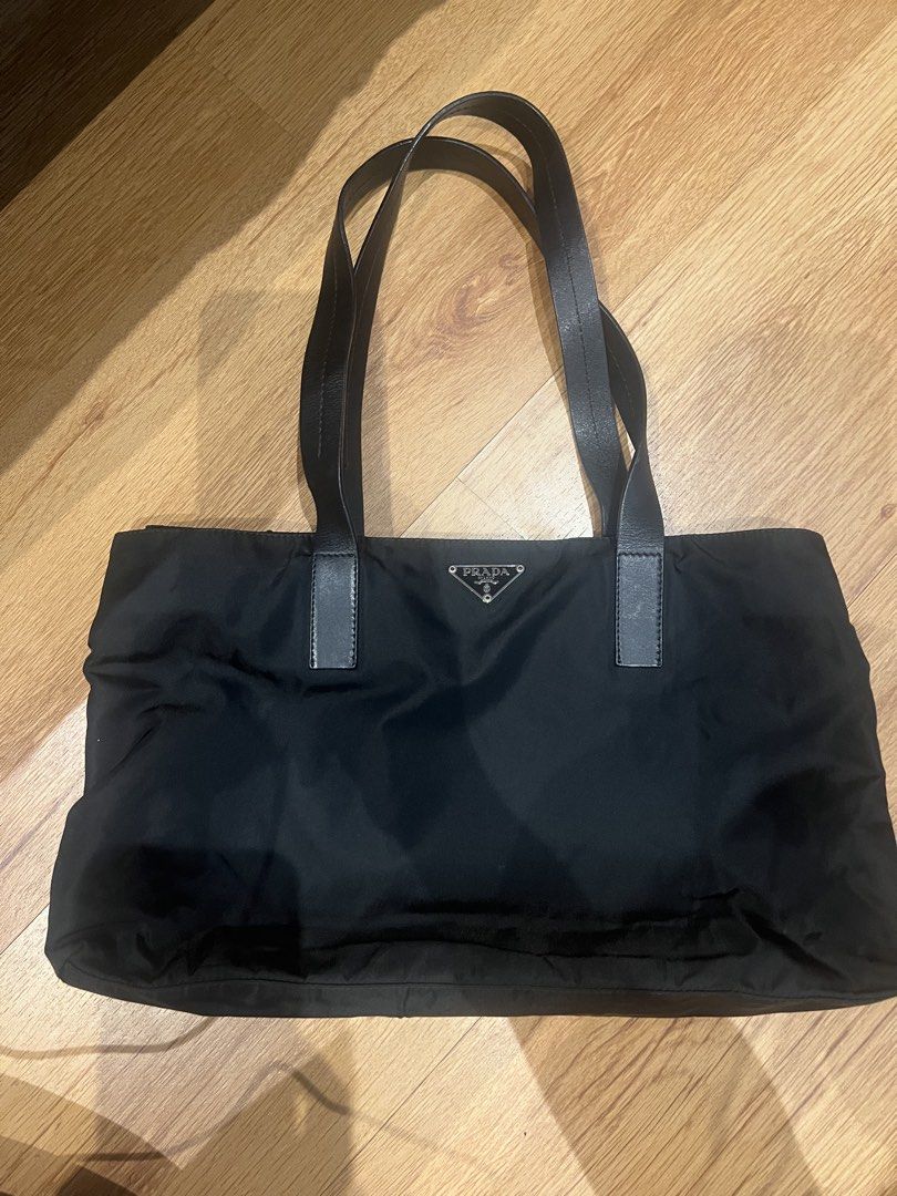 Prada Tessuto Nylon Tote Bag Black (Category: Luxury Bags & Wallets) located in Quezon City. Submitted by lovedbygrace (Listing ID 1451278699, Image 1). Description: - Authentic Prada tote bag - Durable black nylon material - Comfortable leather handles - Interior zip pocket for secure storage - Signature Prada logo lining - Includes authenticity card - Comes with original dust bag - Ideal everyday bag for your essentials.