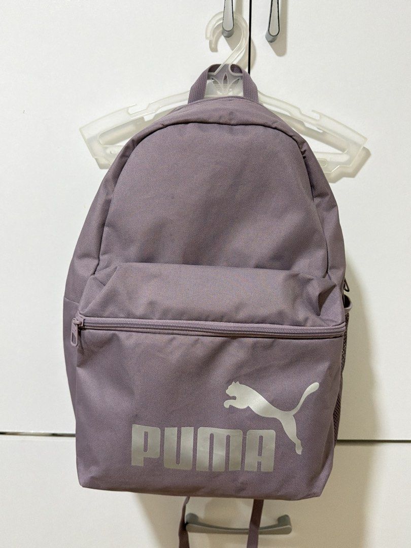 Purple Puma Backpack with Silver Logo (Category: Backpacks) located in Manila. Submitted by alt.declutter (Listing ID 1451226211, Image 1). Description: - Classic Puma backpack with iconic silver logo on the front. - Spacious zippered main compartment for all your essentials. - Convenient front pocket for quick access items. - Side mesh pockets, perfect for water bottles or umbrellas. - Adjustable shoulder straps ensure a comfortable fit for ever