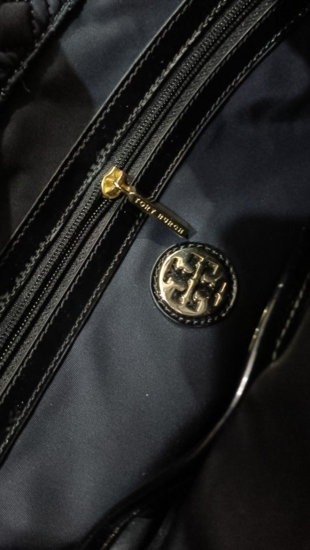 Tory Burch Quilted Tote Bag Black (Category: Luxury Bags & Wallets) located in Manila. Submitted by samutsari_19 (Listing ID 1451259045, Image 2). Description: - Navy blue Tory Burch tote bag - Quilted design with patent leather trim and handles - Interior zip and slip pockets - Gold hardware details - Secure snap closure on top - Ideal for everyday use.