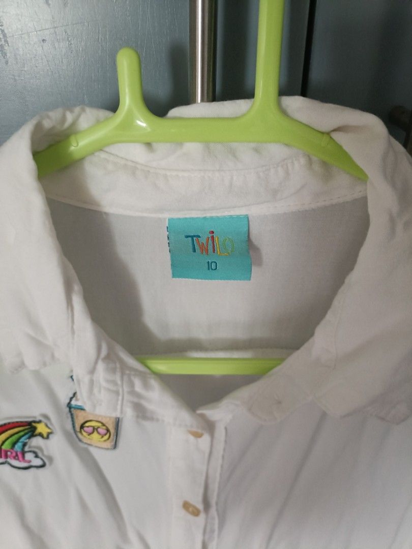 White Shirt with Patches - Size 10 (Category: Babies & Kids Fashion) located in Quezon City. Submitted by qcard13 (Listing ID 1451135799, Image 3). Description: - White long-sleeved shirt - Brand: Twilo - Size: 10, may fit 7-10 year old girls depending on their built. - Adorable embroidered patches: ice cream, rainbow with 'GIRL', coffee cup with sunglasses - Button-down front - Versatile for casual styling.