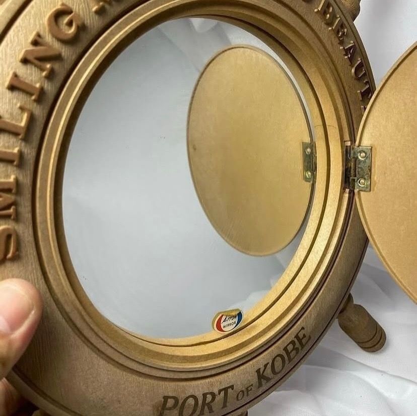 Wooden Ship Wheel Wall Decor with Mirror and Compartment (Category: Mirrors) located in Taguig. Submitted by Rare_findsmnl (Listing ID 1451136439, Image 3). Description: 💴SALE ₱499 Port of Kobe Hanging mirror ₱550 L:15” D:9.2” round base Mirror size 6.5” Last post for tonight 🤩 - Unique wooden ship wheel wall decor - Features a sailing ship design - Includes text: 'SMILING MAKE YOU BEAUTIFUL PORT OF KOBE' - Opens to reveal a mirror - Hidden com