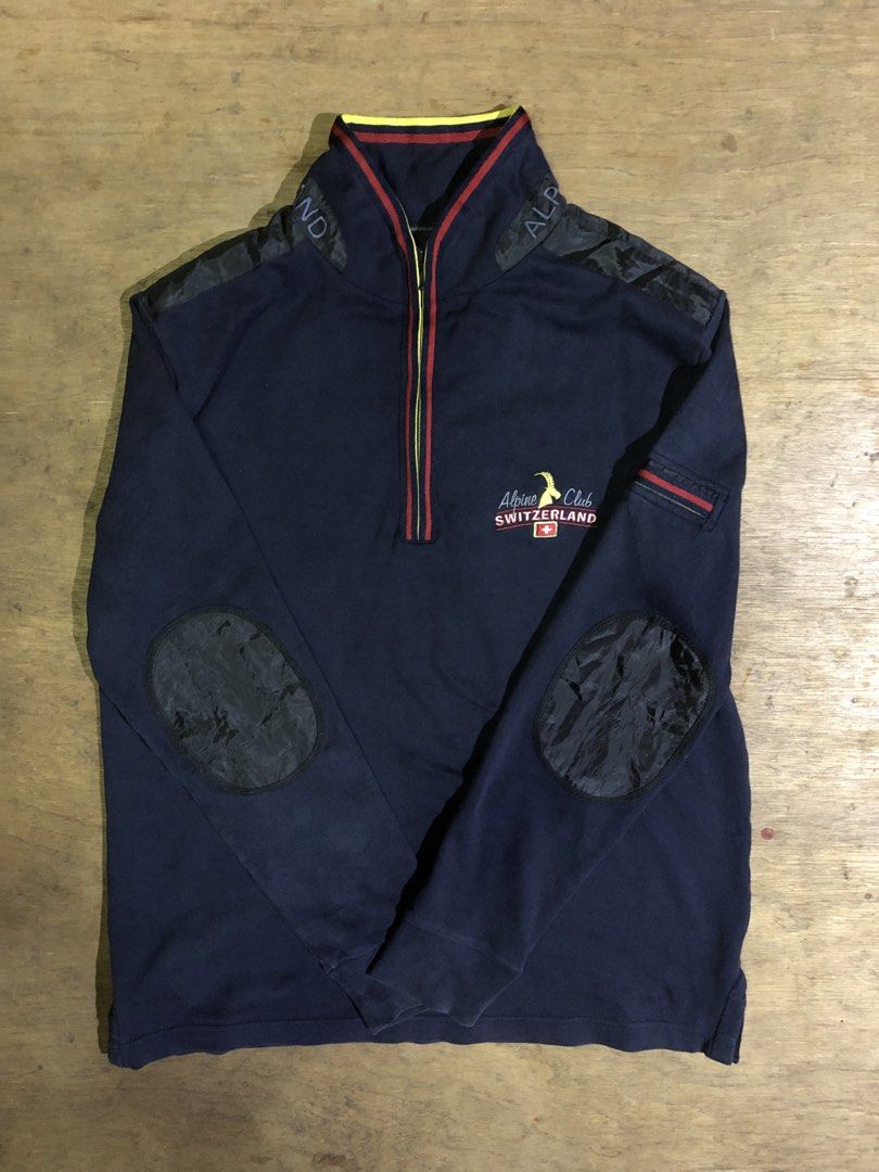 ALPINE CLUB SWITZERLAND SWEATSHIRT (Category: Coats, Jackets and Outerwear) located in Davao. Submitted by blufinds (Listing ID 1451454150, Image 1). Description: This is a navy blue quarter-zip sweatshirt from Alpine Club Switzerland featuring a distinct red, yellow, and blue striped collar and placket detail, as well as an embroidered logo patch on the chest..