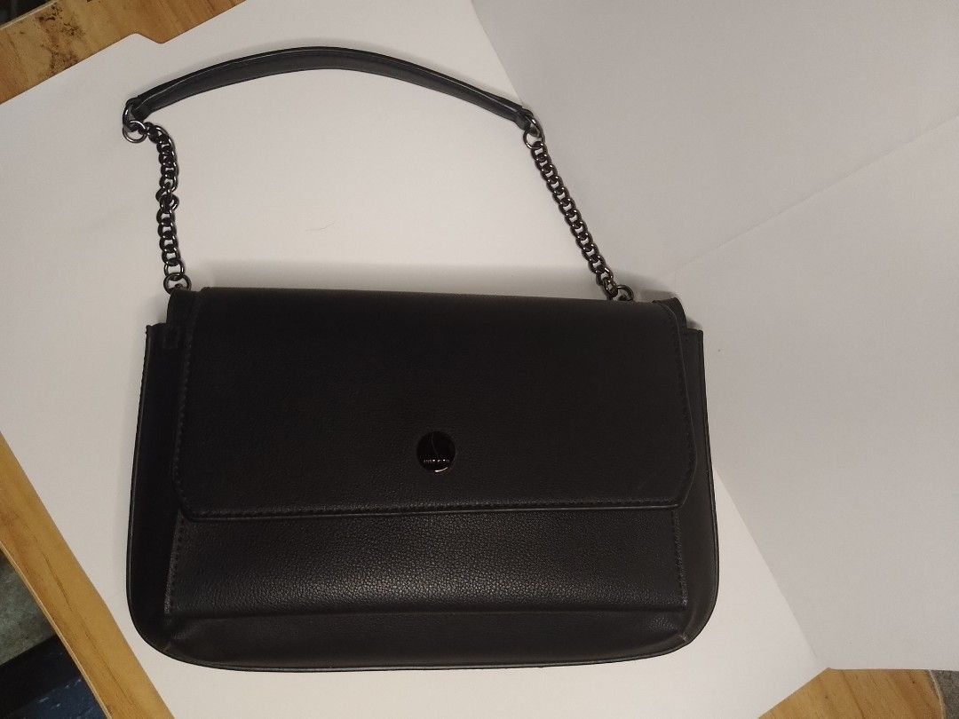 Anne Klein Structured Aesthetic Shoulder Bag (SRP: $70-$100) (Category: Shoulder Bags) located in San Miguel. Submitted by skirt_girlph (Listing ID 1451378360, Image 3). Description: Flap-style structured aesthetic black shoulder bag. Has 2 compartments with inside and back pockets. Has minimal hair lines on opening hardware. Has an unnoticeable mark on the right side of the flap but it can be cleaned (see last photo). Overall like new condition.