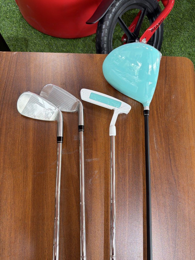 Beginner Golf Club Set - Driver, Putter, Irons (Category: Golf) located in Manila. Submitted by escubursm (Listing ID 1451375737, Image 3). Description: - Complete beginner golf set - Includes: Driver (light blue head), Putter (white with light blue accent), 2 Irons (silver heads, black shafts) - Clubs are brand new, still in protective plastic wrap - Ideal for those new to the game of golf.