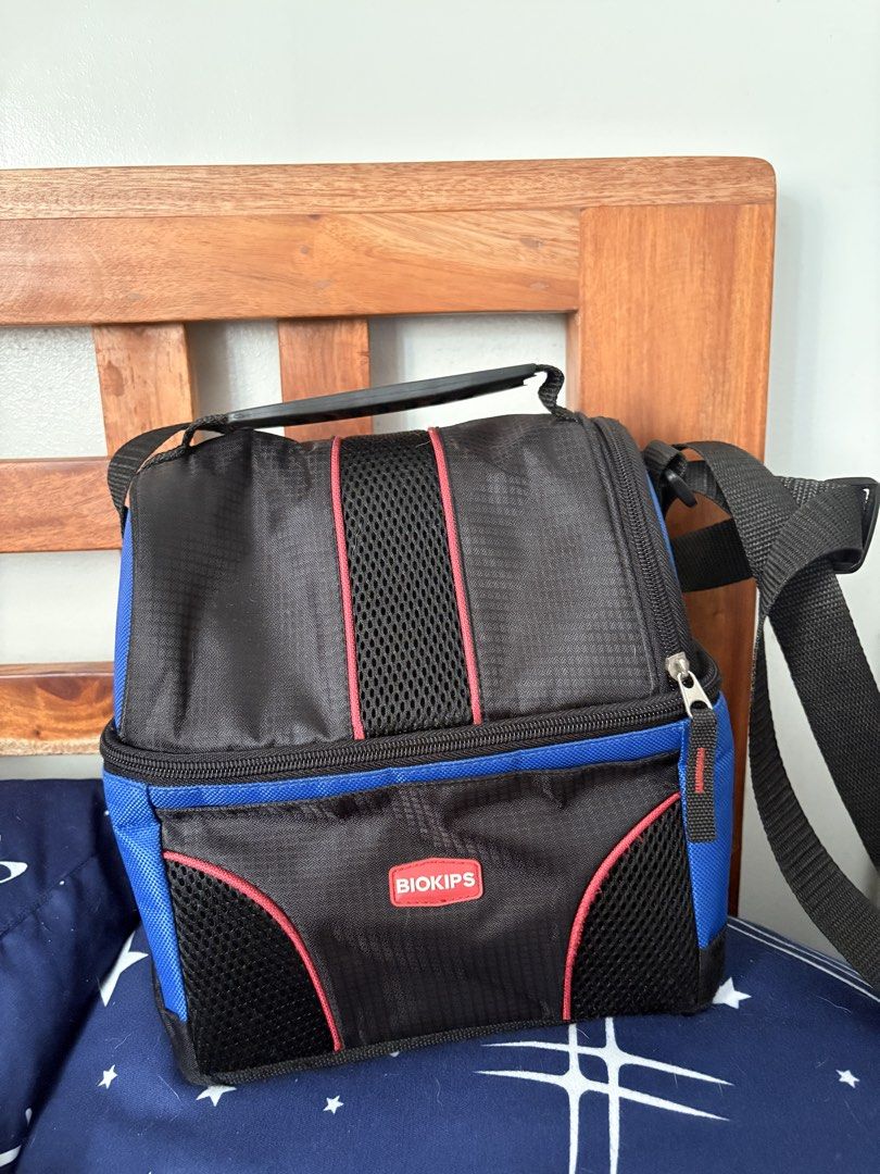 Biokips lunch bag insulated (Category: Storage Boxes & Baskets) located in Makati City. Submitted by ciados (Listing ID 1451341400, Image 1). Description: - Black and blue insulated cooler bag by Biokips. - Ideal for picnics, packed lunches, or keeping items cool. - Features a comfortable handle and an adjustable shoulder strap. - Secure zip-up closure for added protection. - Interior is lined with silver material for enhanced insulation..
