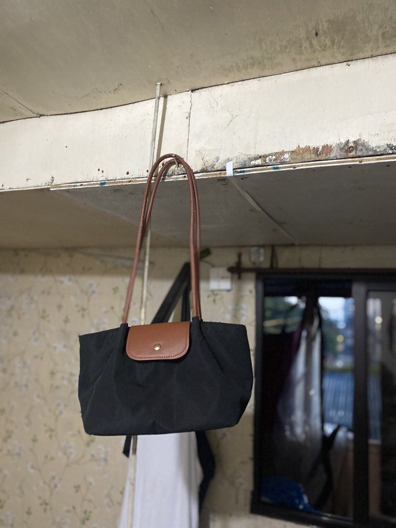 Black Nylon Shoulder Bag with Brown Leather Trim (Category: Shoulder Bags) located in Navotas City. Submitted by corazonfar86465 (Listing ID 1451329969, Image 1). Description: - Cute black nylon shoulder bag - Brown leather accents on handles and flap - Secure button snap closure on flap - Ideal size for daily essentials - Easy and comfortable to carry.