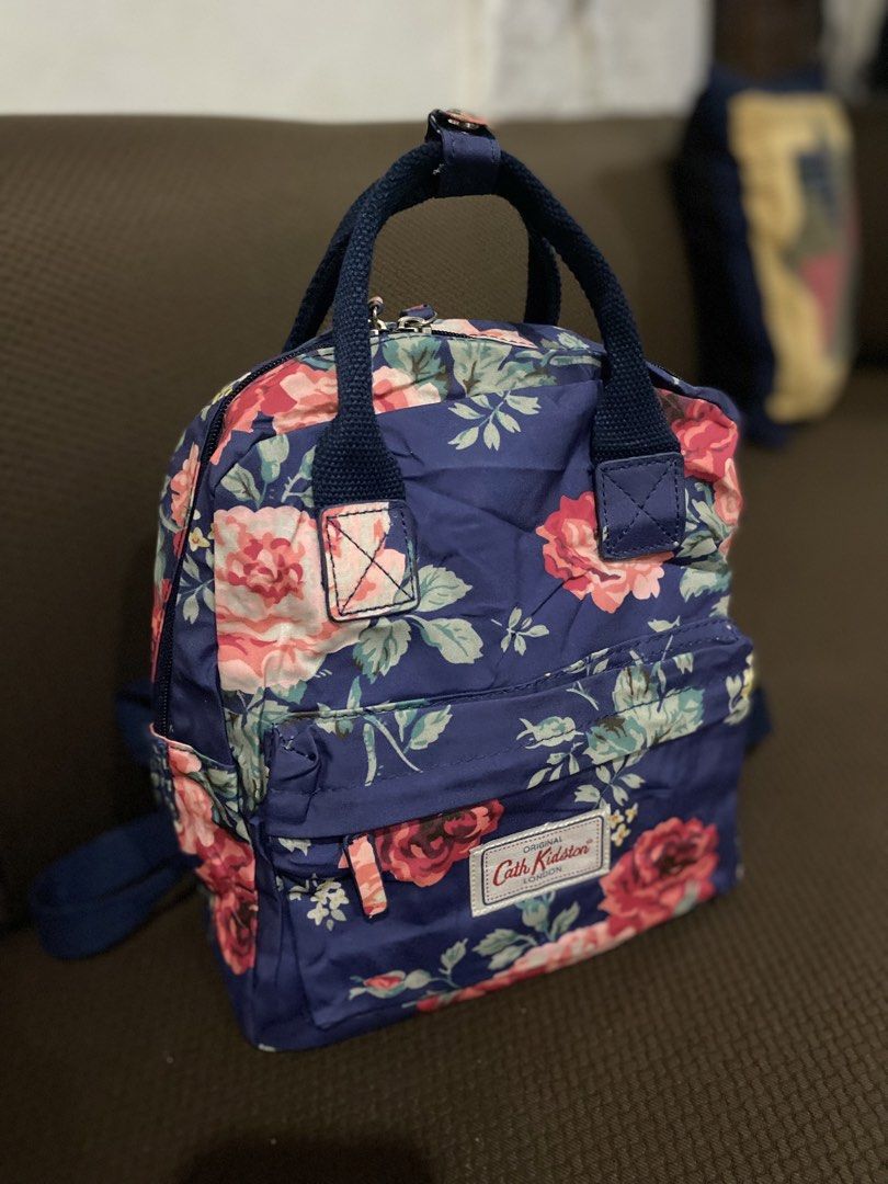 Cath Kidston Backpack Floral Print Navy Blue (Category: Backpacks) located in Cadiz. Submitted by saveandstyleph (Listing ID 1451338715, Image 2). Description: - Cute floral print backpack from Cath Kidston - Navy blue base with pink and red roses - Features a convenient front pocket - Adjustable straps for a comfortable fit - Includes a top handle for easy carrying - Ideal for everyday use or travel adventures.