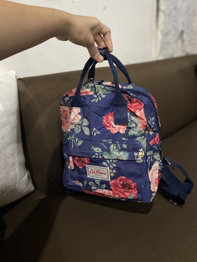 Cath Kidston Backpack Floral Print Navy Blue (Category: Backpacks) located in Cadiz. Submitted by saveandstyleph (Listing ID 1451338715, Image 3). Description: - Cute floral print backpack from Cath Kidston - Navy blue base with pink and red roses - Features a convenient front pocket - Adjustable straps for a comfortable fit - Includes a top handle for easy carrying - Ideal for everyday use or travel adventures.