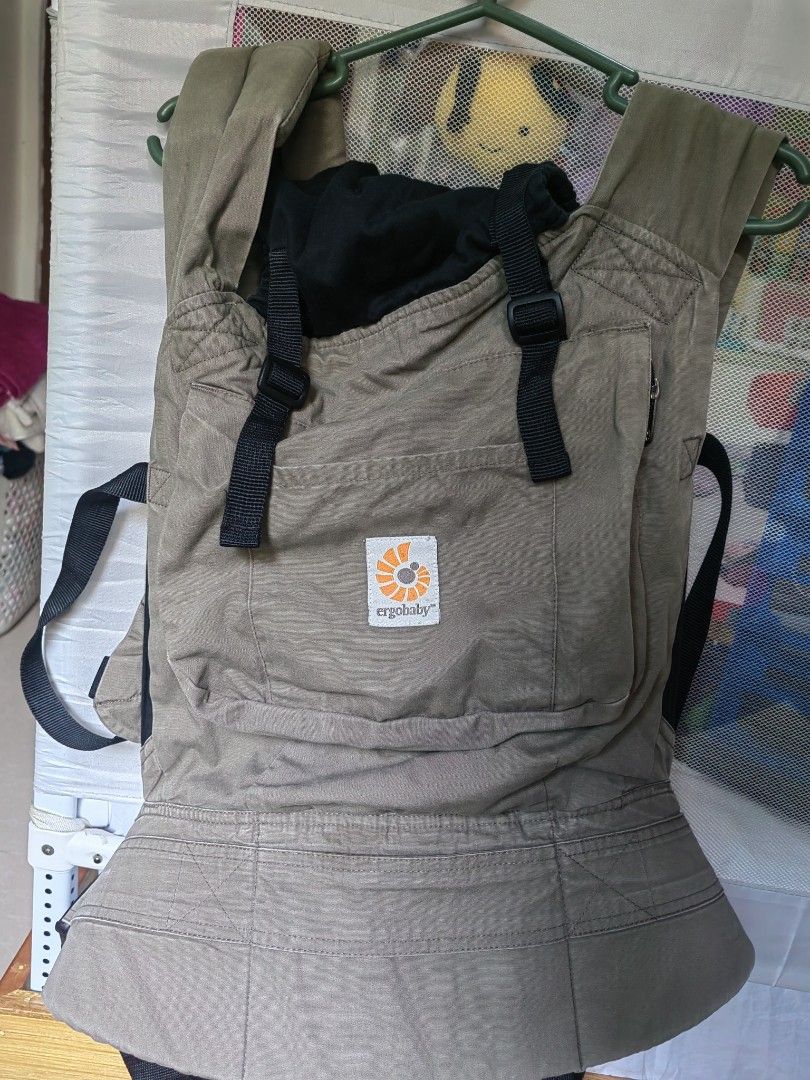 Ergobaby Baby Carrier (Category: Carriers & Slings) located in Caloocan City. Submitted by ruthaguila91340 (Listing ID 1451392500, Image 1). Description: - Ergobaby carrier in a versatile neutral tan color. - Adjustable straps and buckles ensure a secure and comfortable fit. - Features the visible Ergobaby logo on the front pocket. - Perfect for convenient, hands-free carrying. - Designed for comfort for both parent and baby. - Simple and easy to