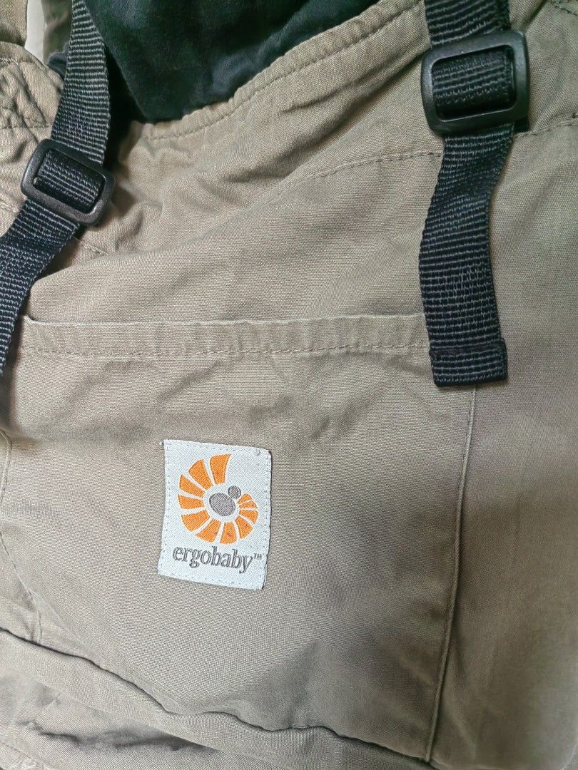 Ergobaby Baby Carrier (Category: Carriers & Slings) located in Caloocan City. Submitted by ruthaguila91340 (Listing ID 1451392500, Image 2). Description: - Ergobaby carrier in a versatile neutral tan color. - Adjustable straps and buckles ensure a secure and comfortable fit. - Features the visible Ergobaby logo on the front pocket. - Perfect for convenient, hands-free carrying. - Designed for comfort for both parent and baby. - Simple and easy to