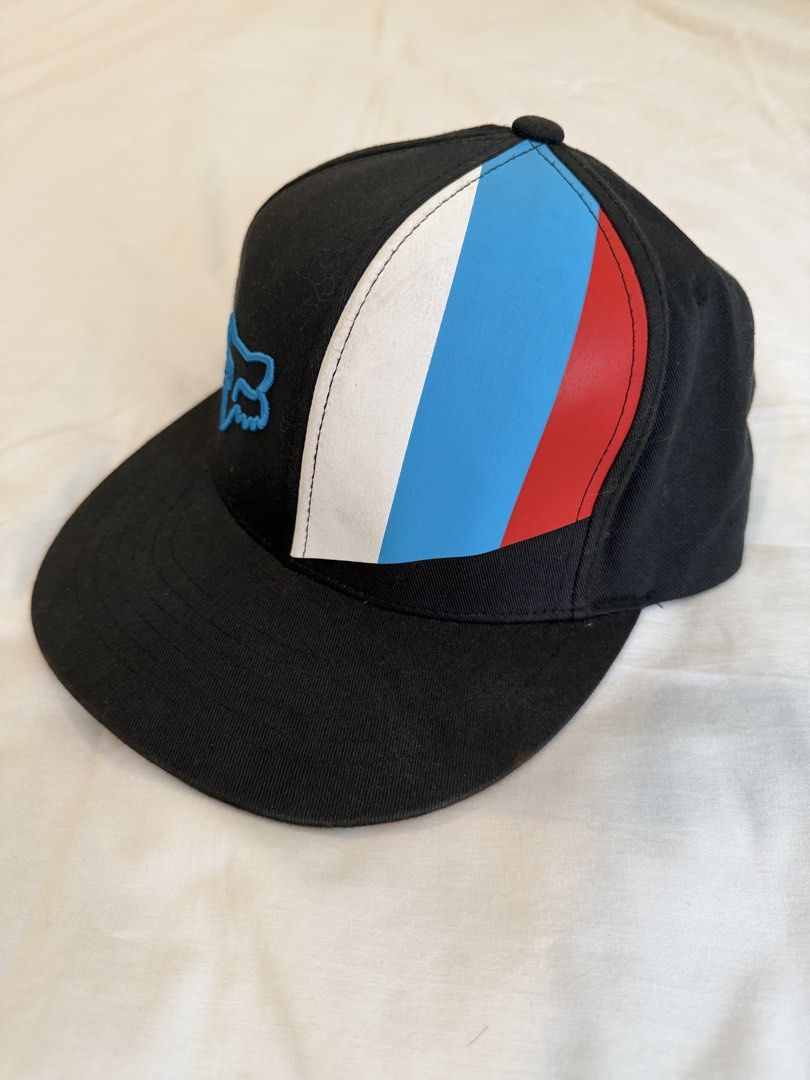 Fox Racing Snapback Cap (Category: Caps & Hats) located in Quezon City. Submitted by harringtonmnl (Listing ID 1451421282, Image 2). Description: - Brand: Black Fox Racing - Style: Snapback Cap - Logo: Iconic Fox head embroidered in blue on the front - Design: Color block with white, blue, and red stripes on the side - Closure: Adjustable snapback for a custom fit - Perfect for: Casual wear, motocross enthusiasts.