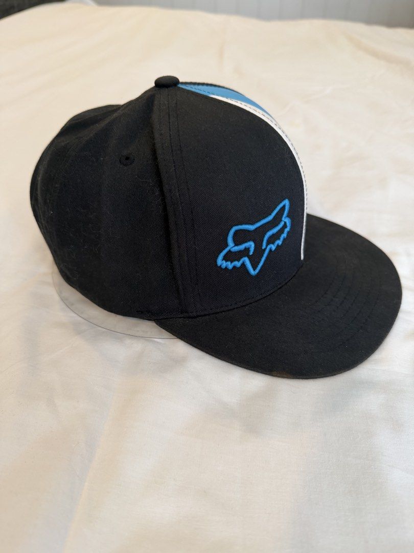 Fox Racing Snapback Cap (Category: Caps & Hats) located in Quezon City. Submitted by harringtonmnl (Listing ID 1451421282, Image 3). Description: - Brand: Black Fox Racing - Style: Snapback Cap - Logo: Iconic Fox head embroidered in blue on the front - Design: Color block with white, blue, and red stripes on the side - Closure: Adjustable snapback for a custom fit - Perfect for: Casual wear, motocross enthusiasts.