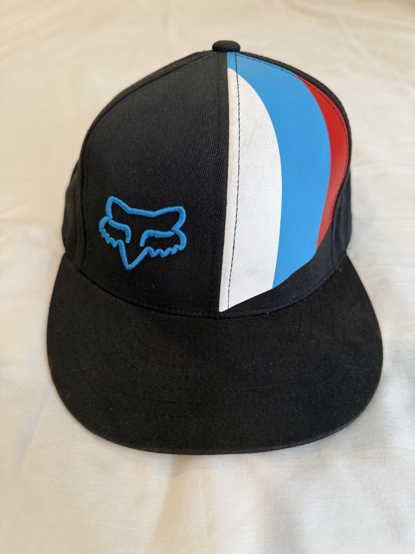 Fox Racing Snapback Cap (Category: Caps & Hats) located in Quezon City. Submitted by harringtonmnl (Listing ID 1451421282, Image 1). Description: - Brand: Black Fox Racing - Style: Snapback Cap - Logo: Iconic Fox head embroidered in blue on the front - Design: Color block with white, blue, and red stripes on the side - Closure: Adjustable snapback for a custom fit - Perfect for: Casual wear, motocross enthusiasts.