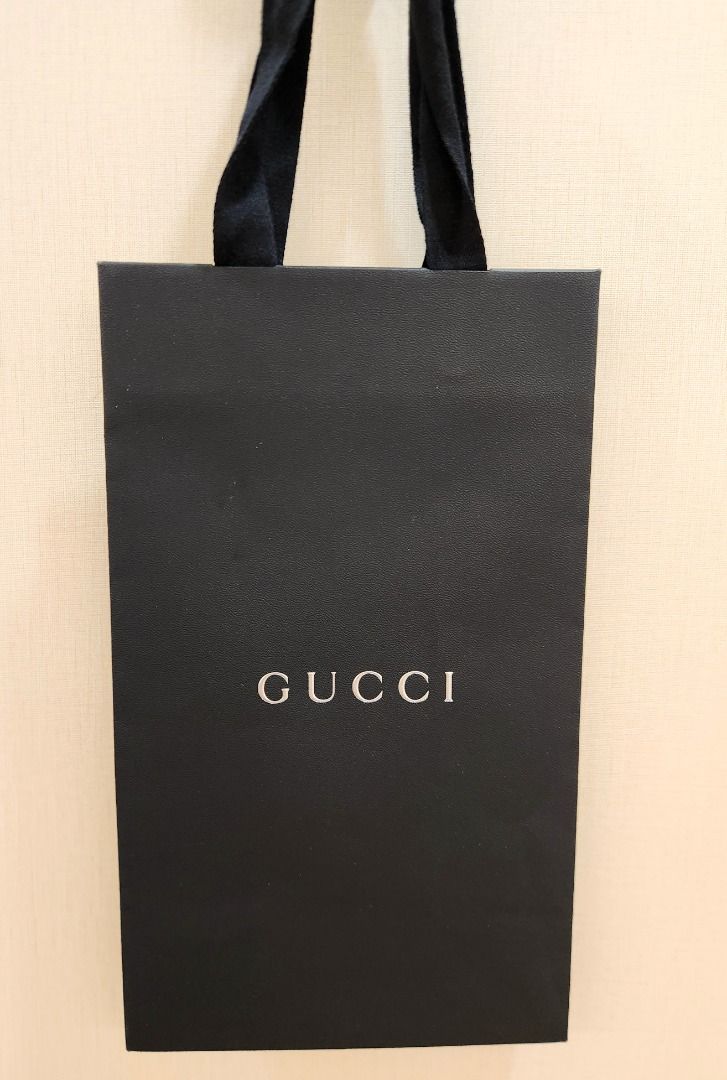 Gucci Black Shopping Bag (Category: Luxury Bags & Wallets) located in Makati City. Submitted by abl320 (Listing ID 1451478132, Image 1). Description: - Authentic Gucci shopping bag - Black paper material - Iconic silver Gucci logo - Ribbon handles - Perfect for gifting or storing small items.
