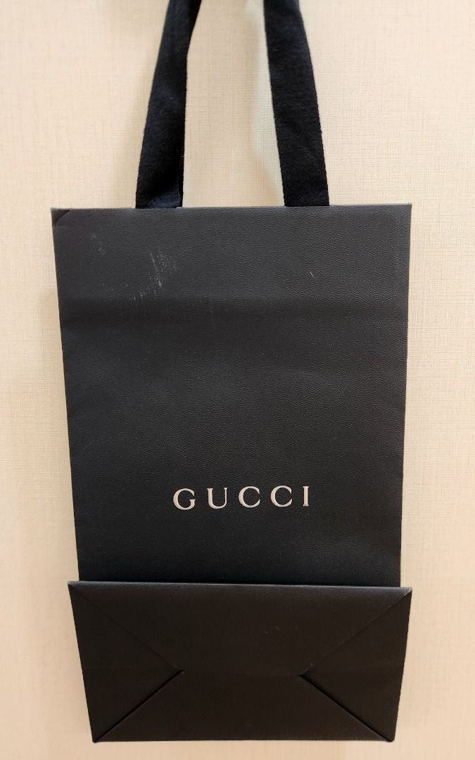Gucci Black Shopping Bag (Category: Luxury Bags & Wallets) located in Makati City. Submitted by abl320 (Listing ID 1451478132, Image 2). Description: - Authentic Gucci shopping bag - Black paper material - Iconic silver Gucci logo - Ribbon handles - Perfect for gifting or storing small items.