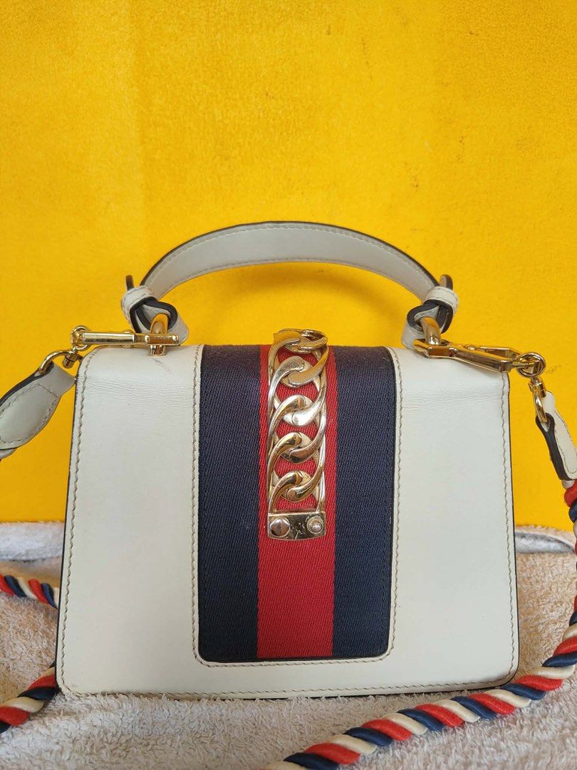 Gucci Sylvie White Leather Top Handle Bag (Category: Luxury Bags & Wallets) located in Alburquerque. Submitted by wildforest.ea4e9c (Listing ID 1446749396, Image 2). Description: - Authentic White Leather Gucci Sylvie Bag - Signature Green and Red Web Stripe - Elegant Gold Chain Detail - Detachable Braided Strap Included - Versatile: Perfect for Day or Night Use - Immaculate Interior Condition - Shiny Gold Hardware.