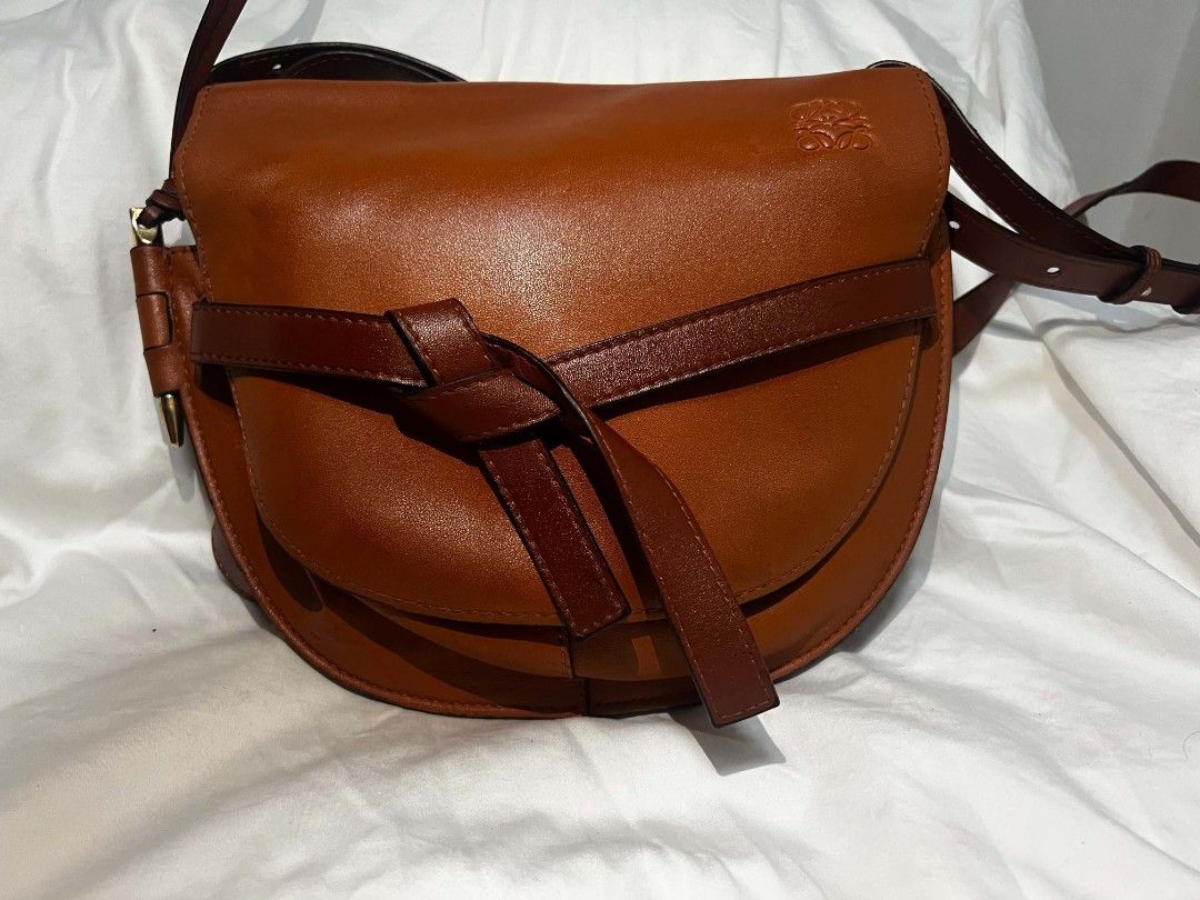 Loewe Gate Small Leather Crossbody Bag Tan (Category: Luxury Bags & Wallets) located in Antipolo. Submitted by happinessprelove (Listing ID 1451456776, Image 1). Description: - Loewe Gate bag - Color: Tan leather - Signature knot detail at the front - Adjustable strap for crossbody or shoulder wear - Gold-tone hardware - Suede lining interior - Made in Spain - Ideal everyday bag.