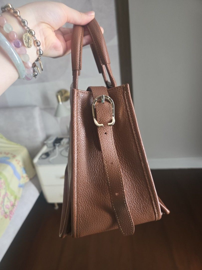 Longchamp Le Foulonné (Category: Luxury Bags & Wallets) located in Pasay City. Submitted by mitchsy15 (Listing ID 1451413682, Image 2). Description: Authentic! price nego!with dustbag Crafted entirely from signature tumbled grained cowhide leather.Features a structured trapeze shape with side snap buttons that expand or collapse the bag's profile.Equipped with sturdy top handles and a detachable crossbody shoulder strap. .
