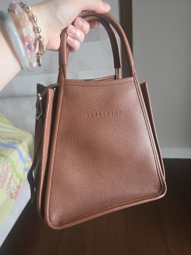 Longchamp Le Foulonné (Category: Luxury Bags & Wallets) located in Pasay City. Submitted by mitchsy15 (Listing ID 1451413682, Image 1). Description: Authentic! price nego!with dustbag Crafted entirely from signature tumbled grained cowhide leather.Features a structured trapeze shape with side snap buttons that expand or collapse the bag's profile.Equipped with sturdy top handles and a detachable crossbody shoulder strap. .