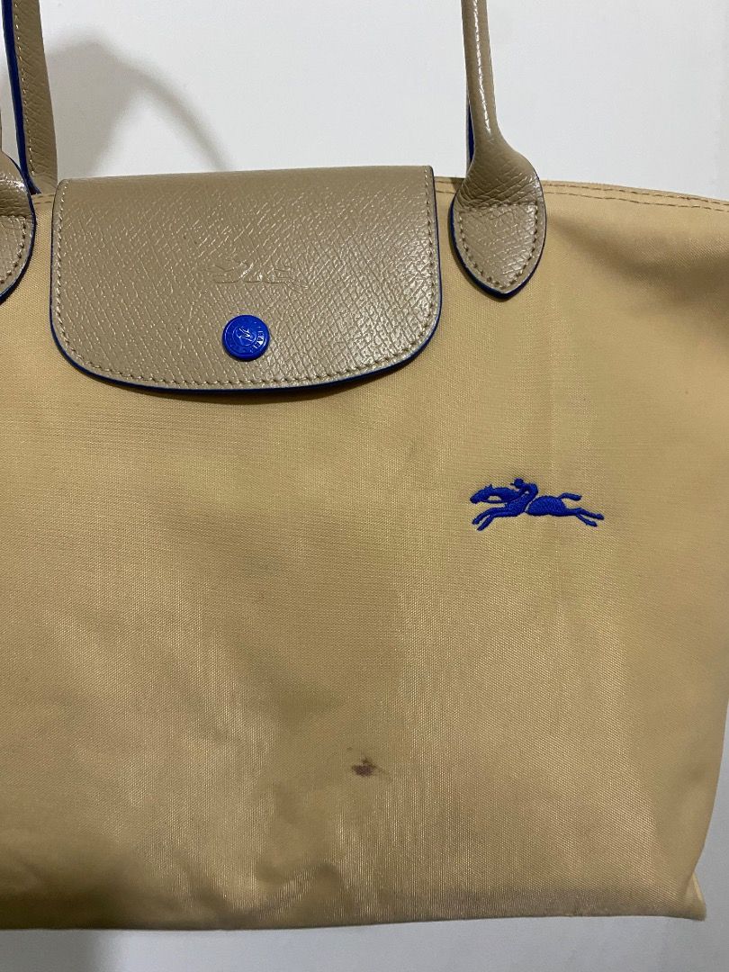 Longchamp Le Pliage Tote Bag Beige (Category: Luxury Bags & Wallets) located in Paete. Submitted by ladder_leynn (Listing ID 1451440520, Image 2). Description: - Classic Longchamp tote bag - Color: Beige nylon with tan leather trim - Iconic embroidered blue horse logo - Closure: Zipper with snap-button flap - Ideal for everyday use.