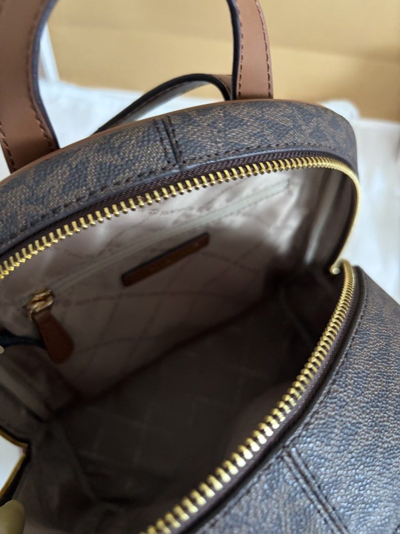 Michael Kors Signature Logo Backpack Brown (Category: Backpacks) located in Manila. Submitted by chiiisells_ (Listing ID 1451394902, Image 3). Description: Original Price is PhP 31,000.00 (82,500.00 yen) - Authentic Michael Kors backpack - Signature brown MK print - Gold hardware and brown leather trim - Main compartment with zip closure - Adjustable shoulder straps - Ideal for everyday use or travel - Comes with original dust bag.