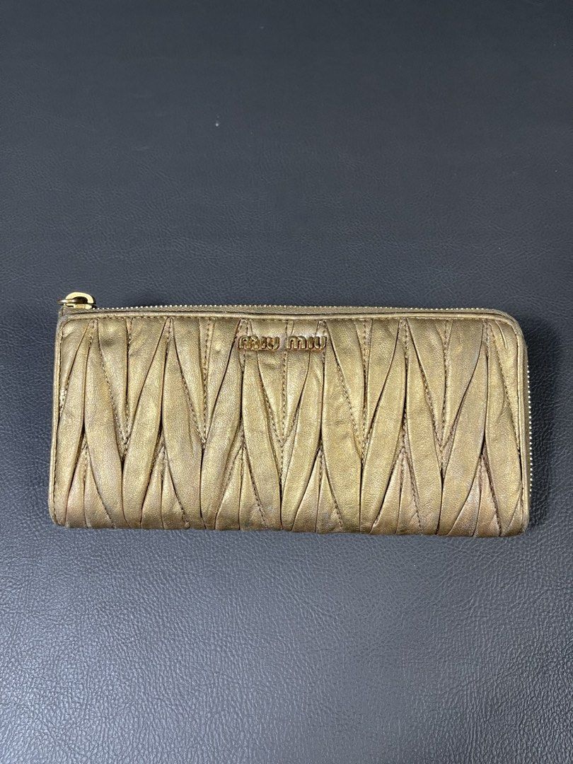 Miu Miu Matelassé Zip-Around Long Wallet (Category: Luxury Bags & Wallets) located in Caloocan City. Submitted by dapreluv (Listing ID 1451436418, Image 1). Description: Miu Miu Matelassé Zip-Around Long Wallet. Brand: Miu Miu Model: Matelassé Zip Around Long Wallet Material: Matelassé (ruched/pleated) lambskin nappa leather Color: Metallic Gold / Bronze Gold Hardware: Gold-tone Era: Approximately 2008–2012 .