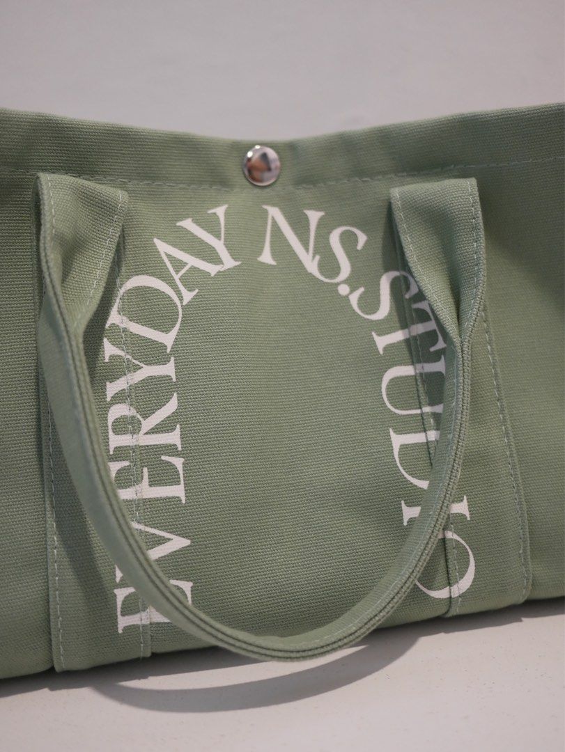 N.S. STUDIO Canvas Tote Bag - Sage Green (Category: Tote Bags) located in Quezon City. Submitted by staysaltyph (Listing ID 1451356758, Image 3). Description: - Sage green canvas tote bag - Brand: N.S. STUDIO - White logo print on front - Snap button closure - Interior pocket - Ideal for everyday use.