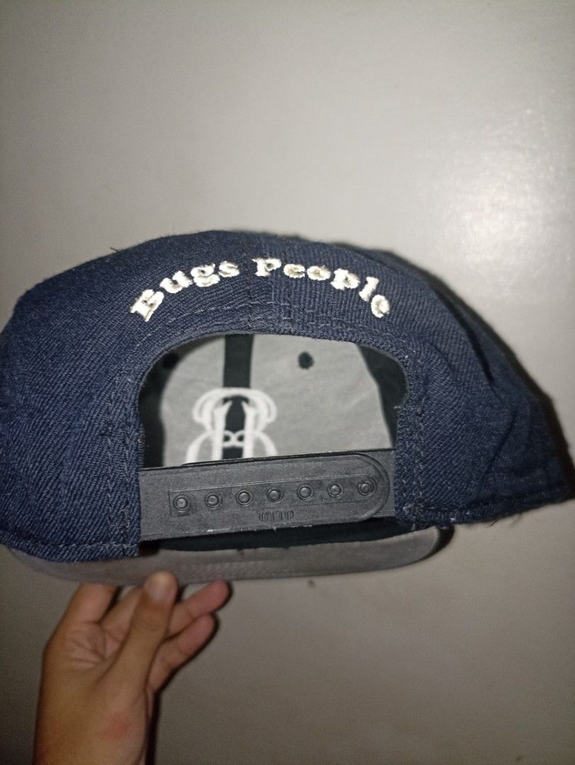 Otto Cap "Bugs People" Snapback Hat (Category: Caps & Hats) located in Pasig City. Submitted by cold.est (Listing ID 1451461007, Image 2). Description: - Dark blue Otto snapback cap - Features a prominent 'B' logo on the front - 'Bugs People' embroidered detail on the back - Adjustable strap for a custom fit - Perfect for everyday casual wear.