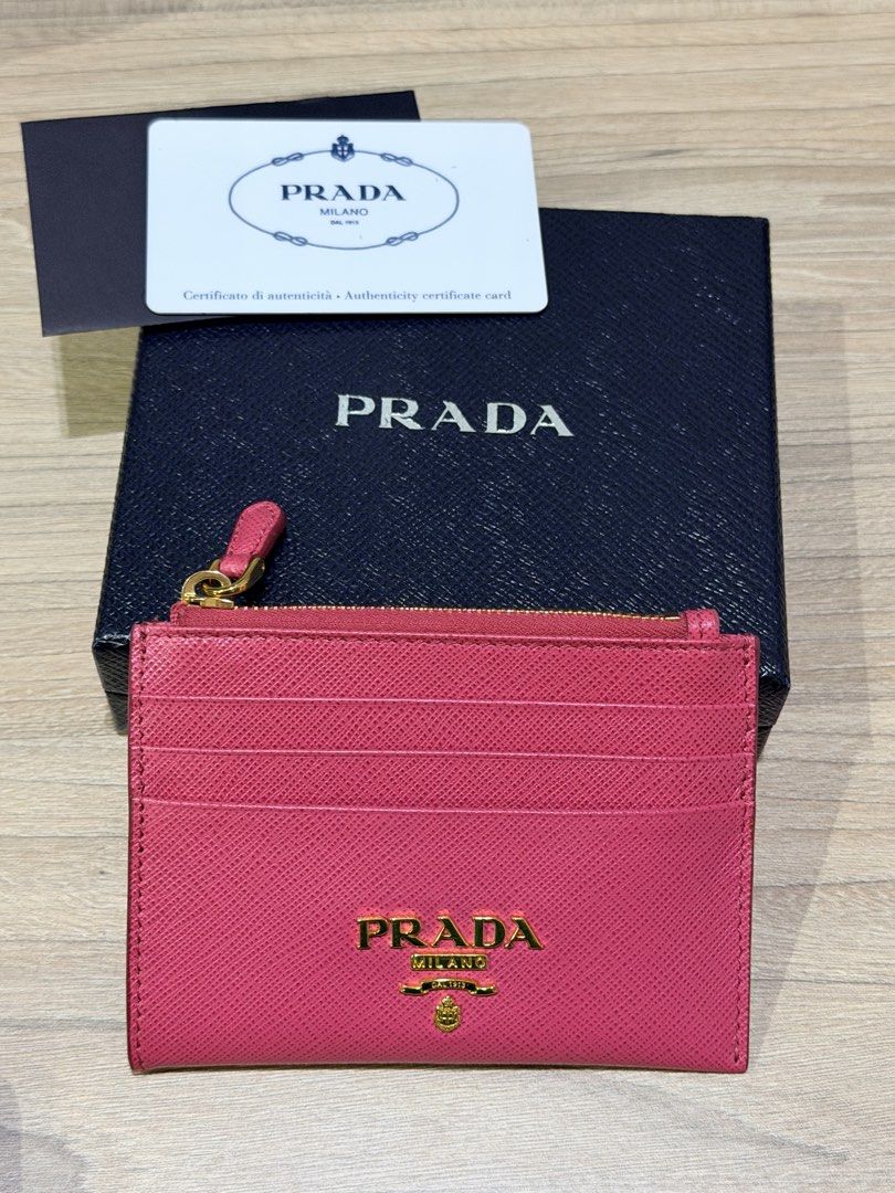 PRADA Saffiano Leather Card Holder Pink (Category: Luxury Bags & Wallets) located in Pasig City. Submitted by theclosetcasemanila (Listing ID 1451479569, Image 1). Description: - Authentic Prada card holder in pink Saffiano leather - Includes original box and authenticity card - Multiple card slots for organization - Zippered compartment for secure storage - Elegant gold hardware details - Perfect for keeping your essentials tidy Excellent condit