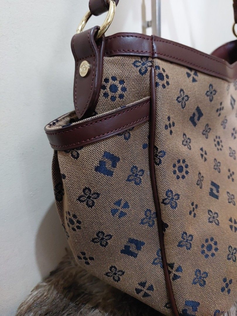 Renoma Monogram Canvas Shoulder Bag (Category: Shoulder Bags) located in Malabon City. Submitted by jullie_bag_shop (Listing ID 1451459779, Image 3). Description: - Brown canvas shoulder bag - Repeating blue monogram pattern - Leather trim and strap - Multiple interior compartments for organization - Gold-tone hardware - Decorative leather tag with Eiffel Tower design - Ideal for everyday use.