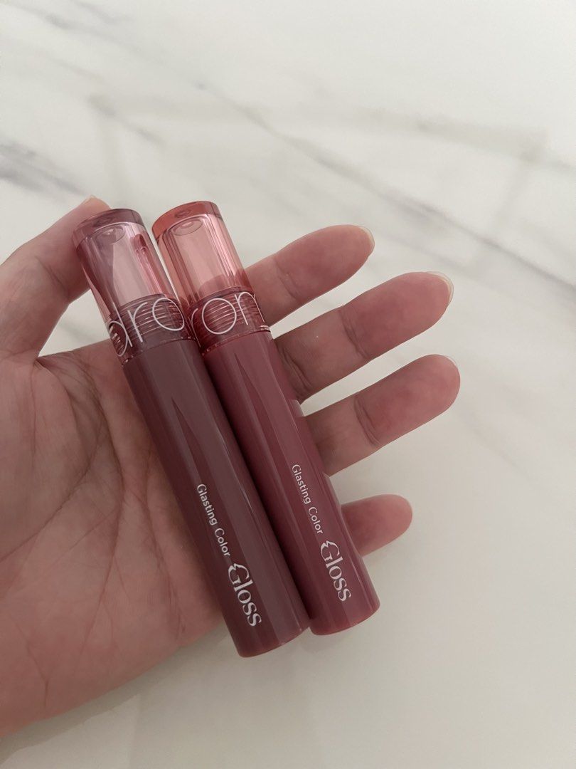 ROM&ND Glasting Color Gloss Lip Tint Set (Category: Makeup) located in Manila. Submitted by lilac.z (Listing ID 1451408194, Image 1). Description: - Set includes 2 ROM&ND Glasting Color Gloss lip tints. - Shades: 05 Dim Mauve and 03 Rose Finch. - Finish: Glossy. - Ideal for achieving a natural lip look. - Selling as a set. - Sterilized (can send proof) - 500 for 2.