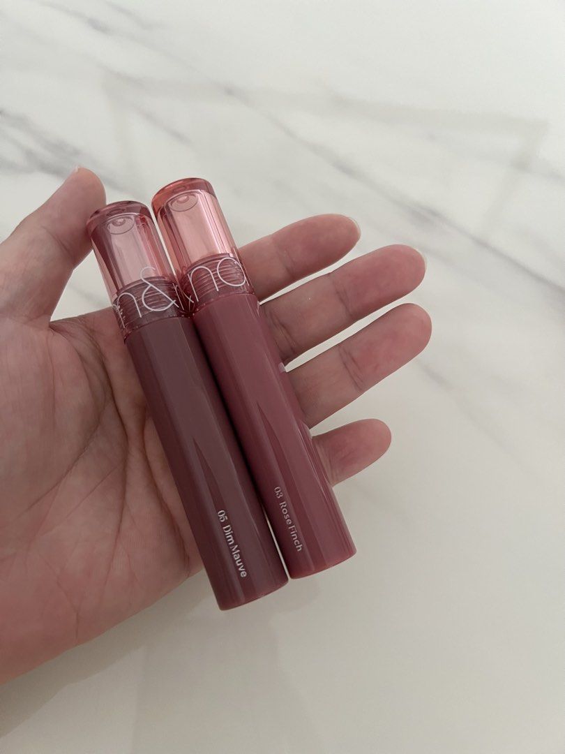 ROM&ND Glasting Color Gloss Lip Tint Set (Category: Makeup) located in Manila. Submitted by lilac.z (Listing ID 1451408194, Image 2). Description: - Set includes 2 ROM&ND Glasting Color Gloss lip tints. - Shades: 05 Dim Mauve and 03 Rose Finch. - Finish: Glossy. - Ideal for achieving a natural lip look. - Selling as a set. - Sterilized (can send proof) - 500 for 2.