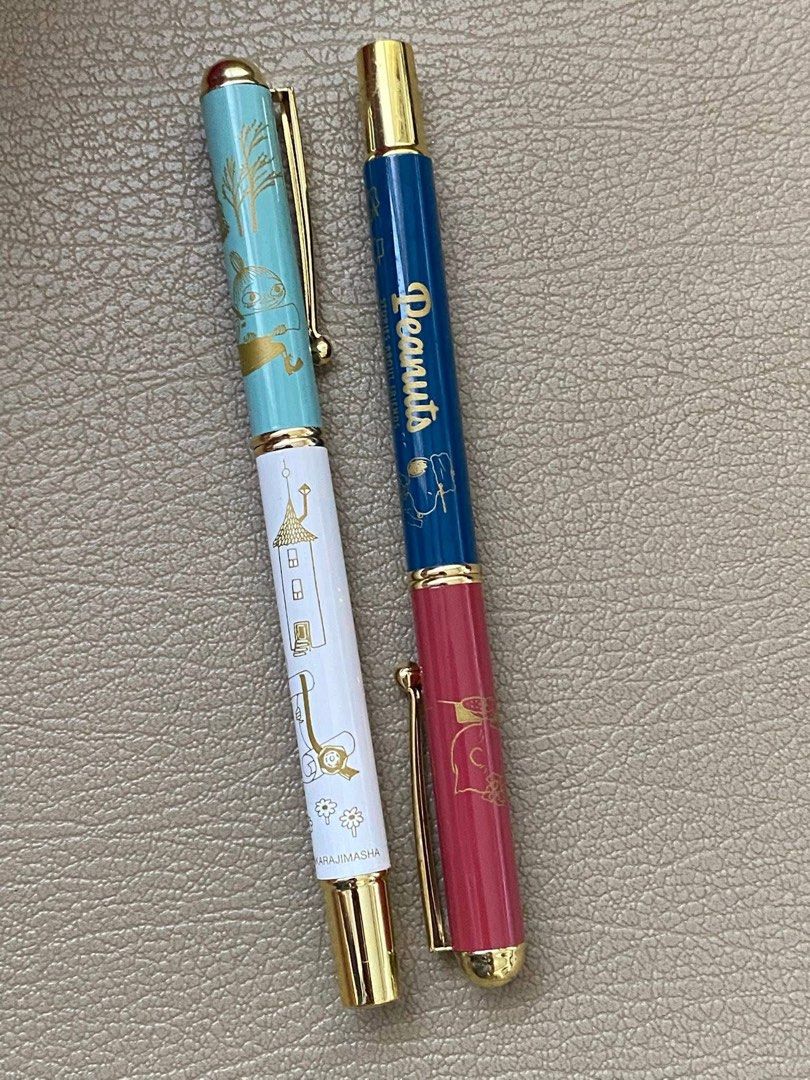 Snoopy Peanuts & Moomin Fountain Pen (Category: Stationery & School Supplies) located in Davao. Submitted by hoowans_surplus (Listing ID 1451504344, Image 1). Description: - Two adorable pens featuring beloved characters: Peanuts and Moomin. - Peanuts pen: Blue barrel with character illustrations. - Moomin pen: Teal and white barrel with Moomin characters and a castle (white barrel has 'KARAJIMASHA' print). - Both pens feature elegant gold accent