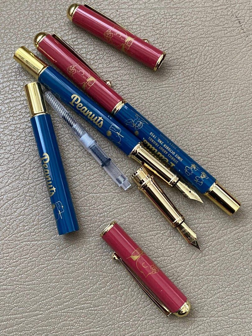 Snoopy Peanuts & Moomin Fountain Pen (Category: Stationery & School Supplies) located in Davao. Submitted by hoowans_surplus (Listing ID 1451504344, Image 2). Description: - Two adorable pens featuring beloved characters: Peanuts and Moomin. - Peanuts pen: Blue barrel with character illustrations. - Moomin pen: Teal and white barrel with Moomin characters and a castle (white barrel has 'KARAJIMASHA' print). - Both pens feature elegant gold accent
