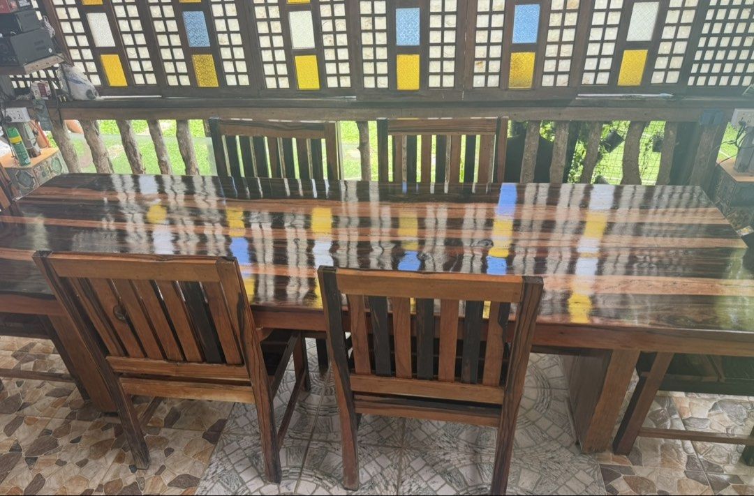Solid Wood Dining Table and Chairs Set (Category: Tables & Sets) located in Pasig City. Submitted by silverrabbit_997049 (Listing ID 1451377650, Image 1). Description: - Beautiful solid wood dining set 12 seater - Includes large table and 6 chairs - Rich, dark wood finish with natural grain patterns - Comfortable and sturdy chairs - Perfect for family gatherings and entertaining guests - Ideal for dining room or patio.