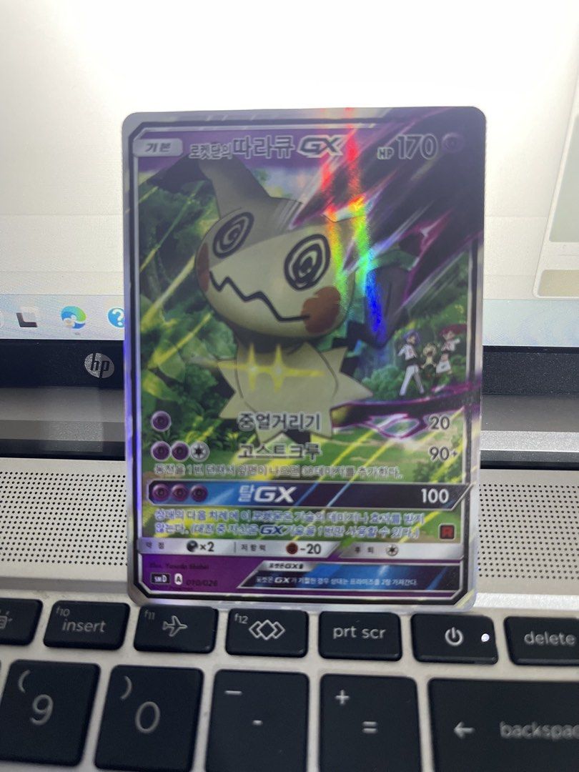 Team Rocket’s Mimikyu GX (Category: Raw Singles) located in Taguig. Submitted by mineme22 (Listing ID 1451418341, Image 1). Description: 🏷️ Title: Team Rocket’s Mimikyu GX 010/026 Full Art Holo (Korean Language) 💵 Price: ₱5000 Description: Team Rocket’s Mimikyu GX (010/026) Full art holofoil card from the Sun & Moon era Language: Korean Card Type: Ultra Rare / GX Condition: Lightly Played Features: Unique artwork featuring Jessie, James, and Me