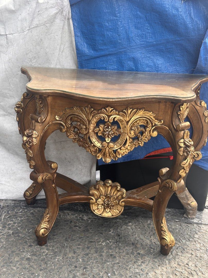 Vintage Ornate Gold Console Table with Mirror (Category: Tables & Sets) located in Quezon City. Submitted by anjherga27 (Listing ID 1451394434, Image 3). Description: - Vintage ornate gold console table - Features intricate carvings and a glass top - Includes a matching mirror with a decorative gold frame and white accents - Perfect for entryway or vanity - Minor signs of wear on table legs.