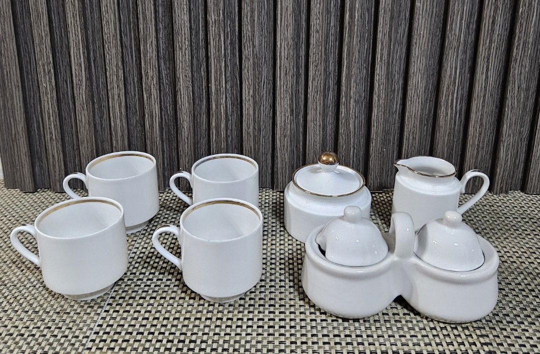 White Ceramic Tea Set with Gold Trim (Category: Coffee & Tea Tableware) located in Rizal. Submitted by cherry_garcia (Listing ID 1451386420, Image 1). Description: - Complete white ceramic tea set - Includes: 4 cups, sugar bowl with lid, creamer pitcher, double condiment dish with lids - Features elegant gold trim on cup and pitcher rims - Sugar bowl has a decorative gold knob - Condiment dish includes a convenient handle - Ideal for serving gues