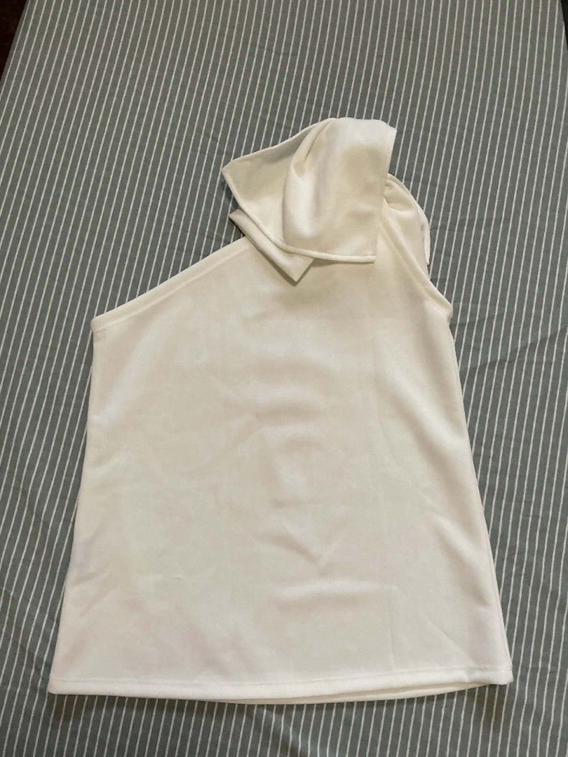 White One-Shoulder Top with Bow Detail (Category: Blouses) located in Quezon City. Submitted by dcltrrr8 (Listing ID 1451411890, Image 2). Description: - White one-shoulder top - Features a cute bow detail on the shoulder strap - Made from a soft, comfortable fabric - Perfect for dressing up or down - Easily pairs with skirts or pants.